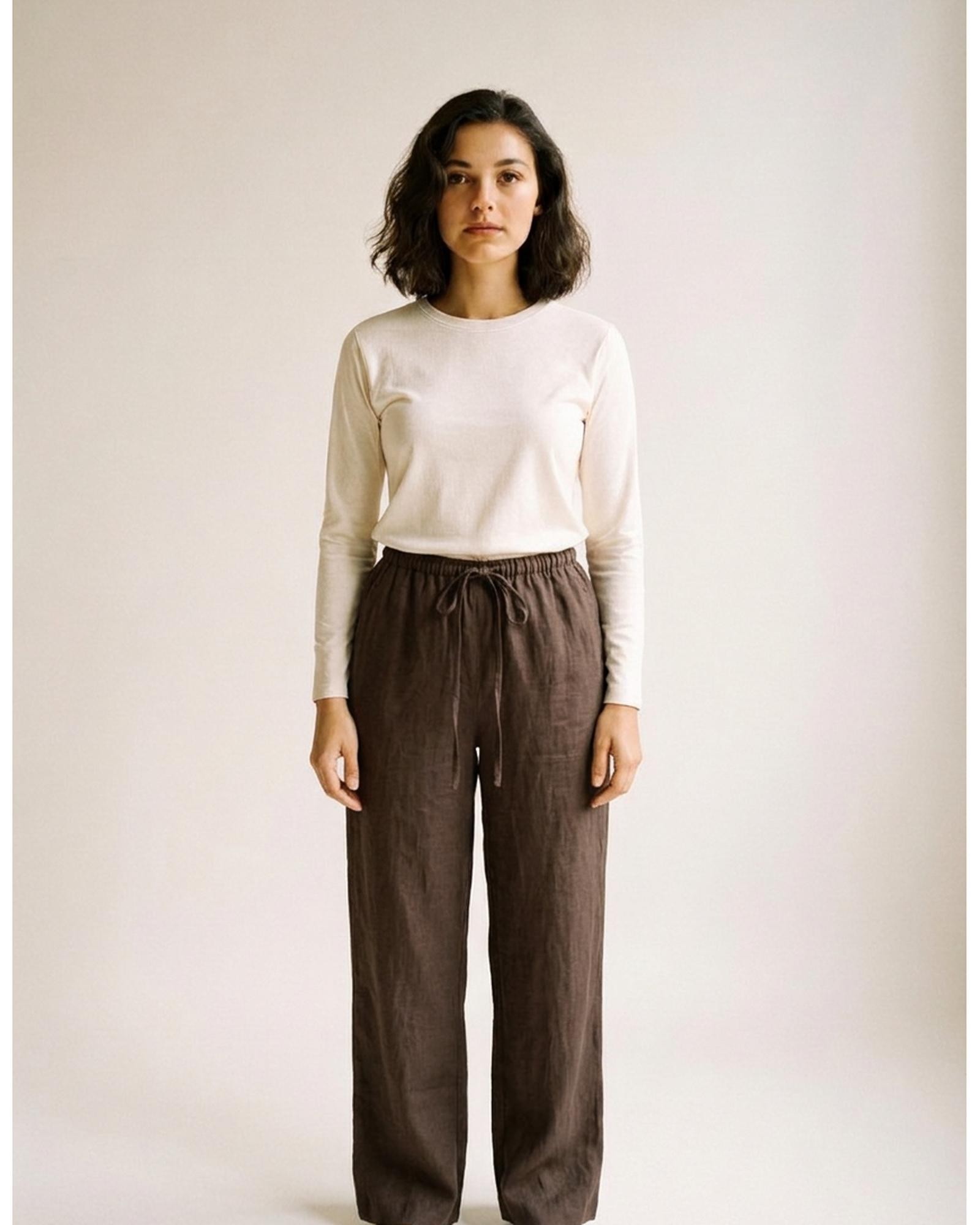 Bregtje · High-waist linen wide-leg trousers — dark brown, worn front (AI visualisation)