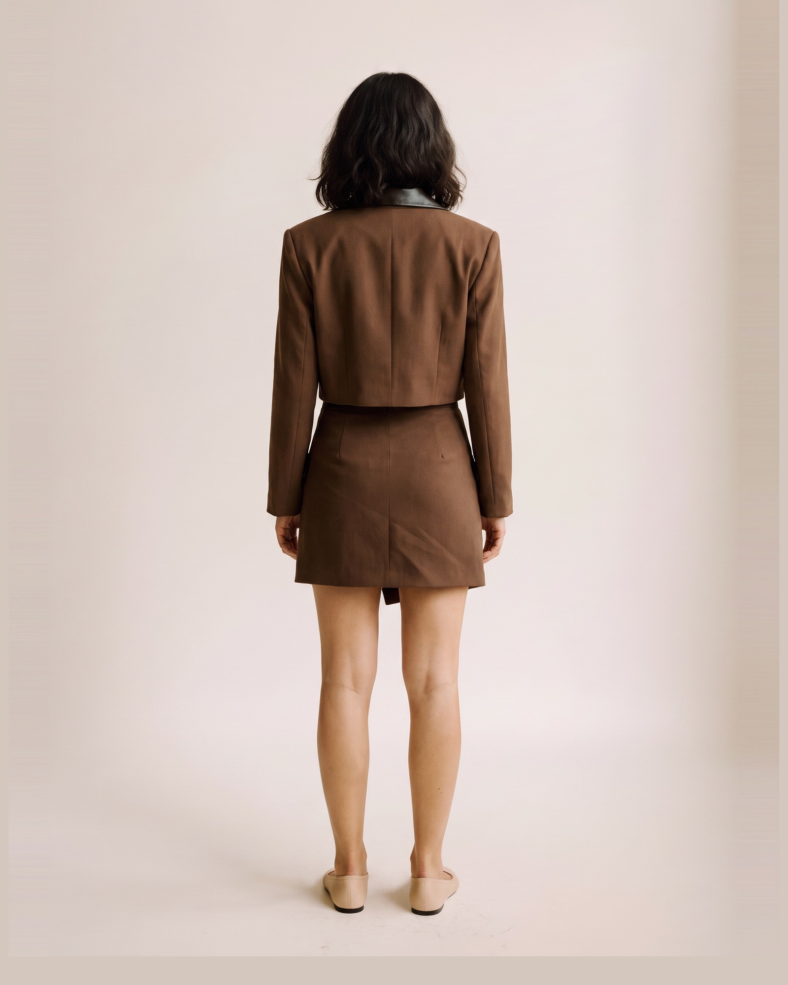 Jantine wool blazer and mini skirt set — op model, achteraanzicht (AI-visualisatie)