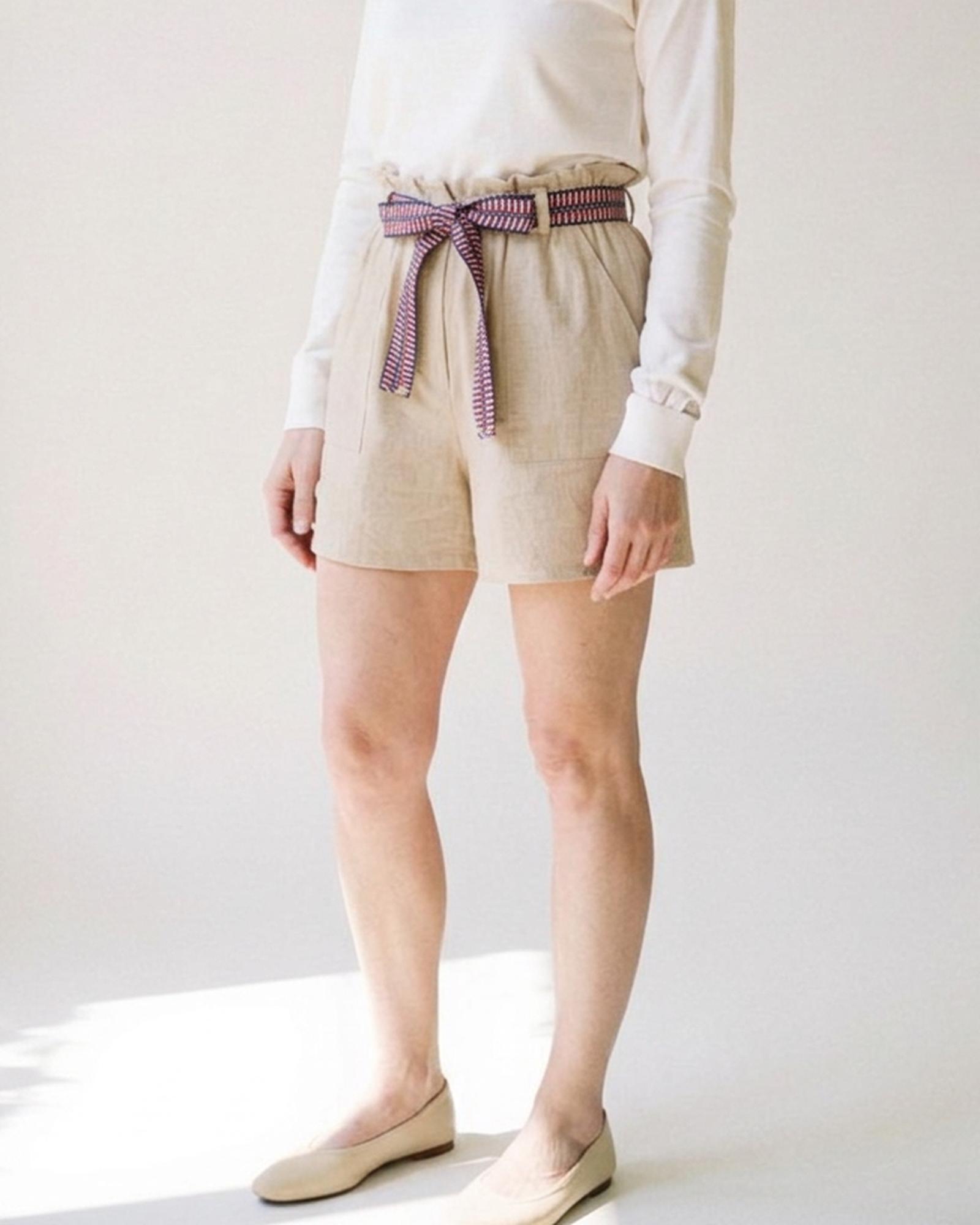 Lieneke · Paperbag tie-belt shorts — on model, three-quarter (AI visualisation)