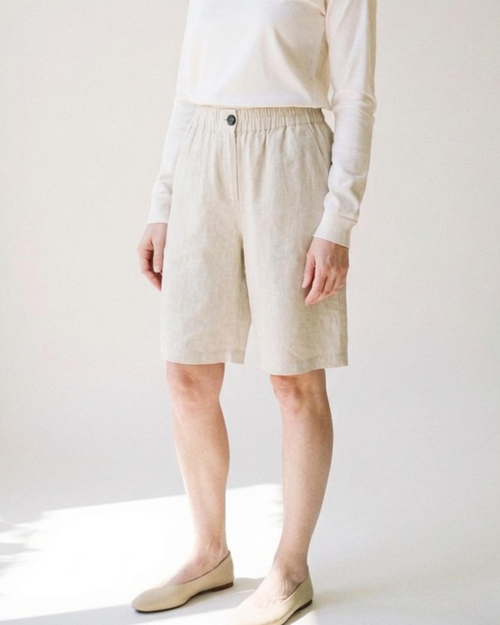 Nynke · Linen bermuda shorts — on model, three-quarter (AI visualisation)
