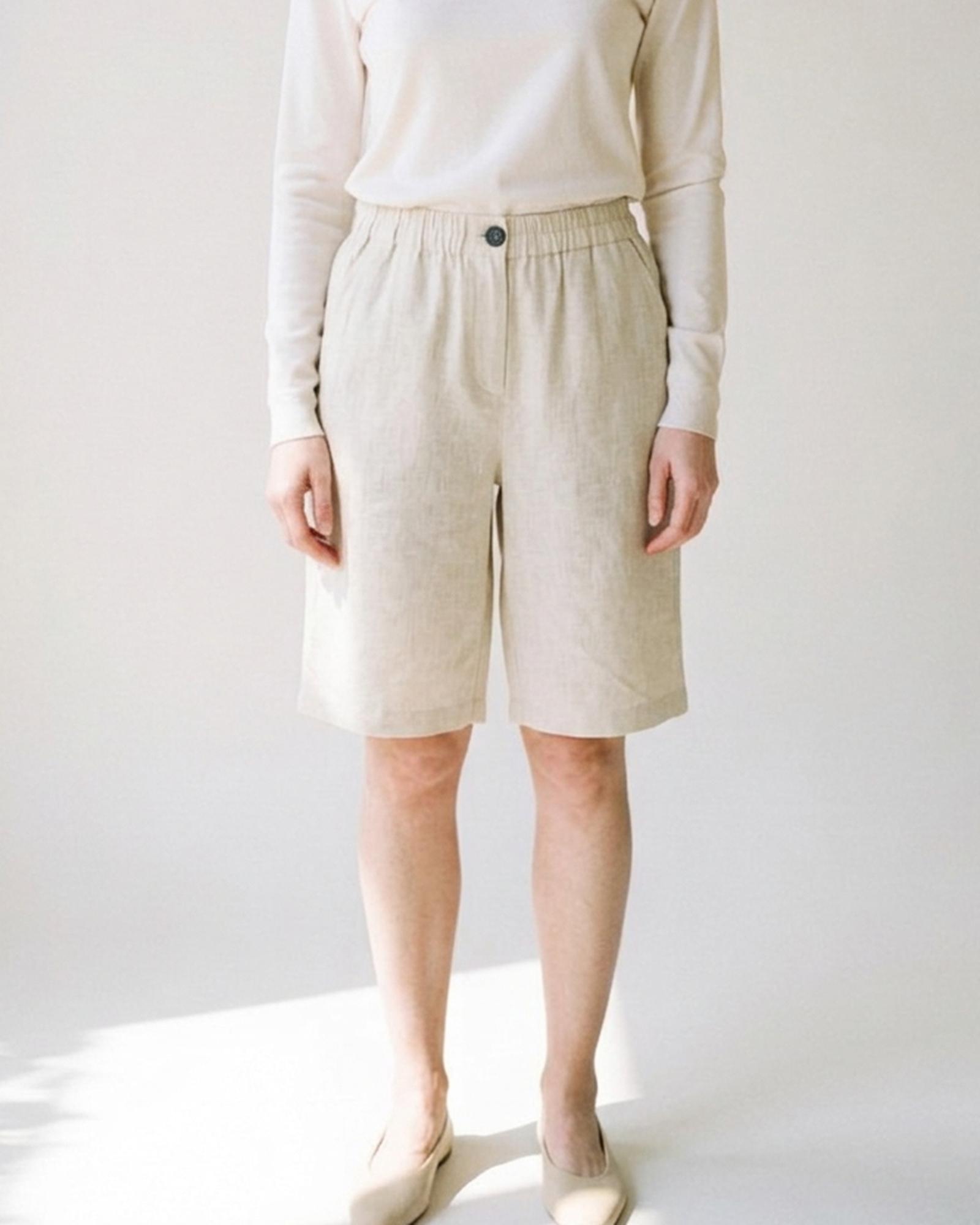Nynke · Linen bermuda shorts — on model, front (AI visualisation)