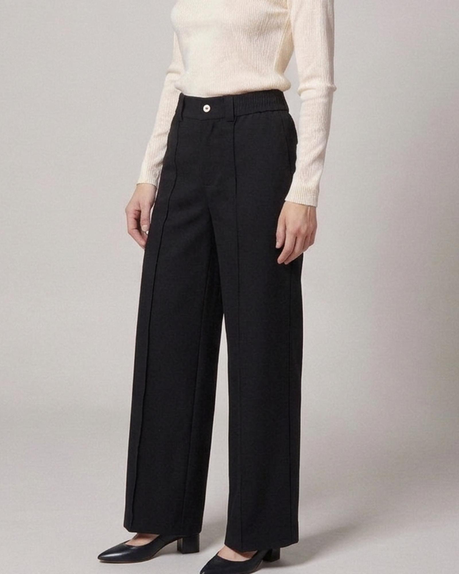 Renske · Draped high-waist trousers — on the model, three-quarter view (AI visualisation)
