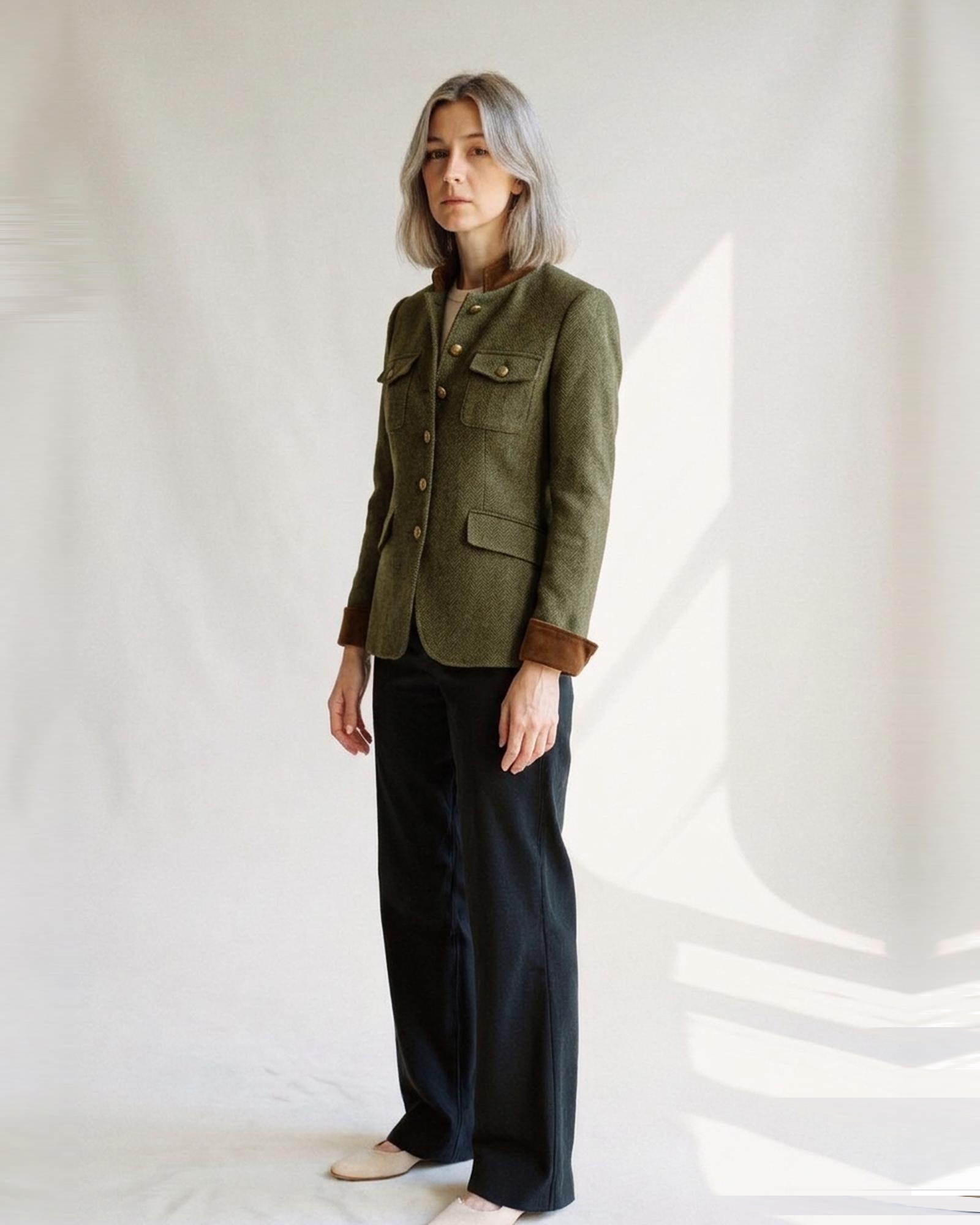 Gonda olive-green herringbone tweed blazer with military stand collar, chest flap pockets, brown corduroy cuffs and brass buttons, three-quarter view (AI visualisation)